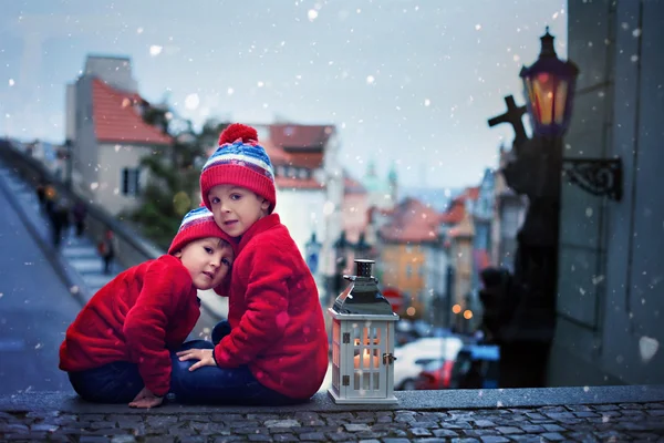 Zwei Kinder, die auf einer Treppe stehen, eine Laterne in der Hand, Blick auf pragu — Stockfoto