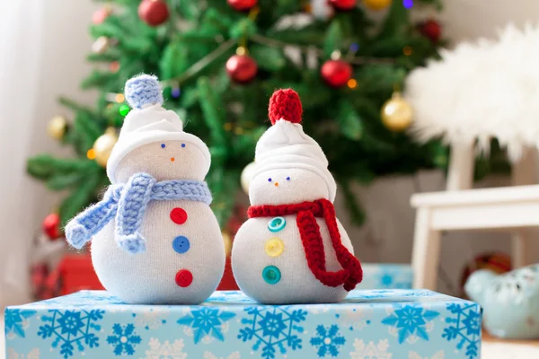 Zwei handgefertigte Schneemänner mit weihnachtlichem Hintergrund auf weißem Fell — Stockfoto