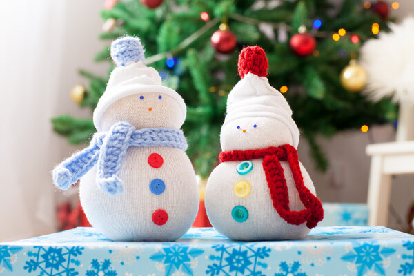 Два снеговика ручной работы на фоне Рождества на белом мехе
