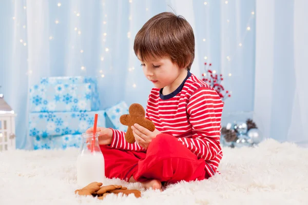 Lindo niño feliz, comiendo galletas y bebiendo leche, esperando —  Fotos de Stock