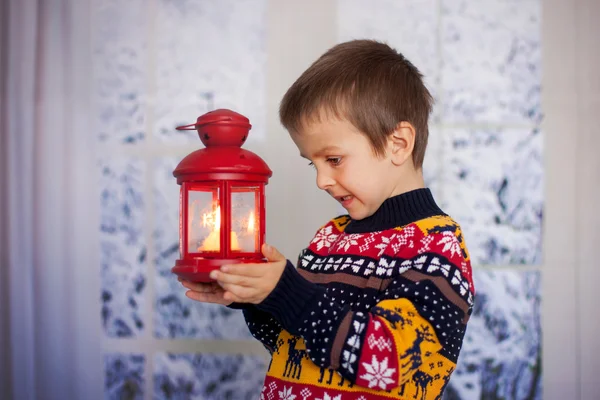 Dulce niño, sosteniendo la linterna en casa en un día nevado — Foto de Stock