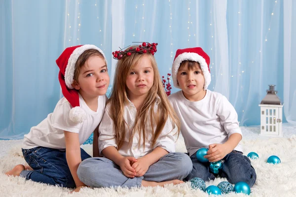 Два маленьких брата-близнеца и их старшая сестра, рождественская концепция — стоковое фото