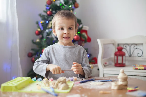 Cute little boy, playing with modeling dough, molding figures at home on Christmas — Stock Photo, Image