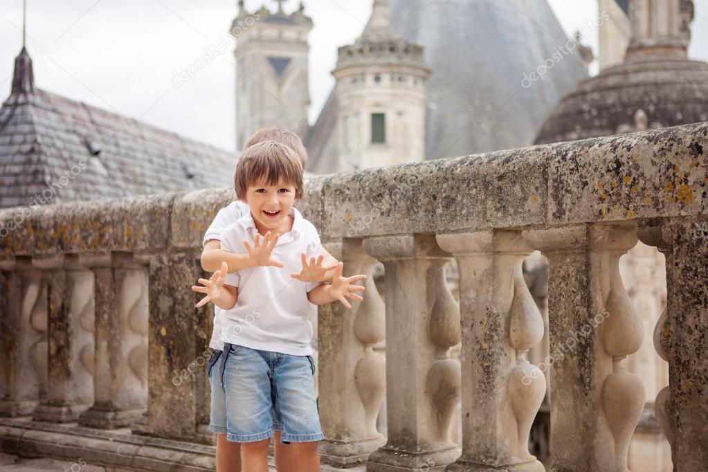 Two sweet boys, brothers having fun while walking around a castl