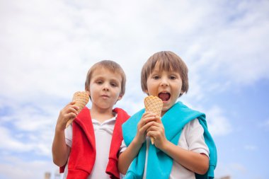 Unusual portrait from below of kids, eating ice cream