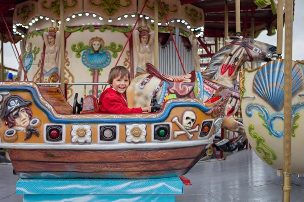 Sweet boy, riding in a train on a merry-go-round, carousel attra — 图库照片