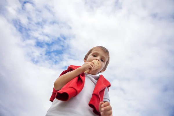 Unusual portrait from below of kid, eating ice cream — Stock fotografie