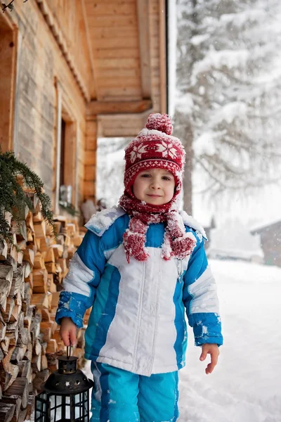 Roztomilý chlapeček s lucernou, stojící před zimní — Stock fotografie