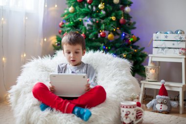 Fasulye çanta, tablet üzerinde oynarken üzerinde oturan sevimli küçük hasta çocuk