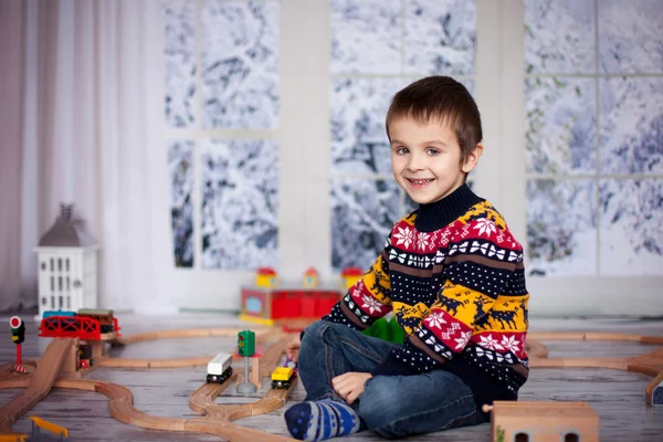 Bedårande liten förskola pojke, leker med trä tåg och ra — Stockfoto