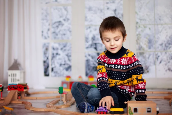 Adorable petit garçon d'âge préscolaire, jouer avec des trains en bois et ra — Photo