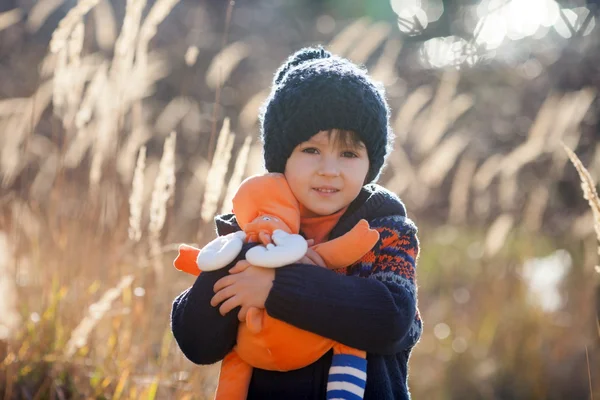Niedliche kleine kaukasische Kind, Junge, hält flauschiges Spielzeug, umarmt es — Stockfoto