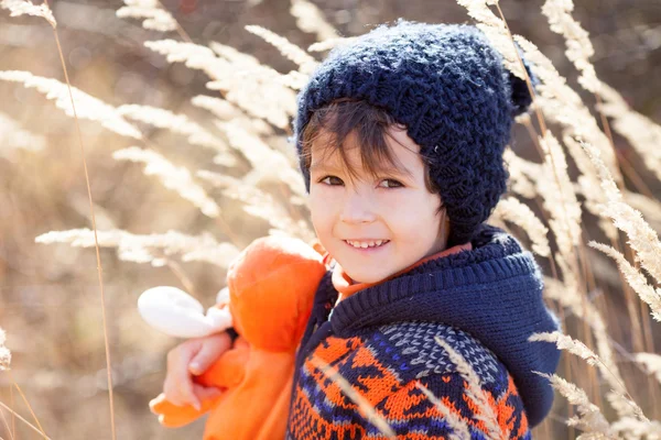 Niedliche kleine kaukasische Kind, Junge, hält flauschiges Spielzeug, umarmt es — Stockfoto