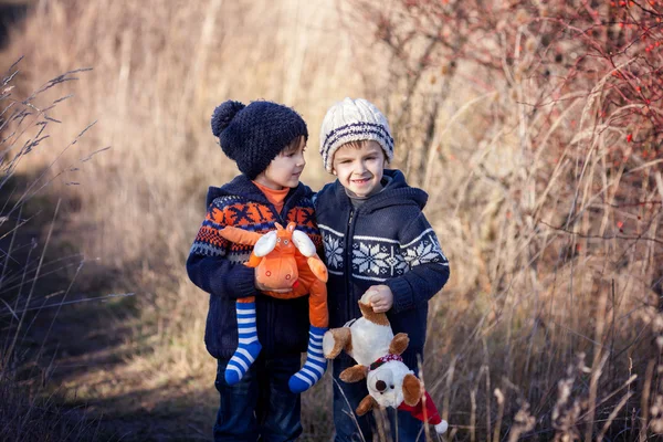 Dos niños dulces con osos de peluche, jugando en el parque en un soleado —  Fotos de Stock