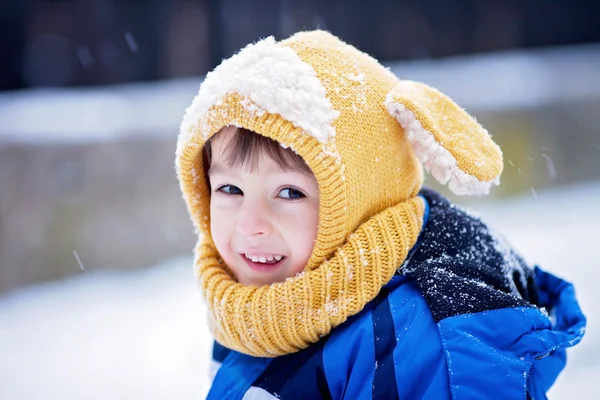 Ragazzino carino, giocare con la neve nel parco, parco giochi — Foto Stock