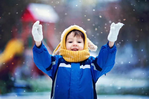 Schattige kleine jongen, spelen met sneeuw in het park, Speeltuin — Stockfoto