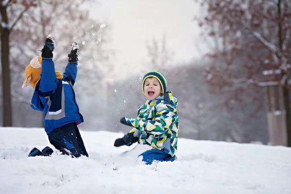 Δύο αγόρια, αδέρφια, παίζοντας στο χιόνι με χιονόμπαλες — Φωτογραφία Αρχείου