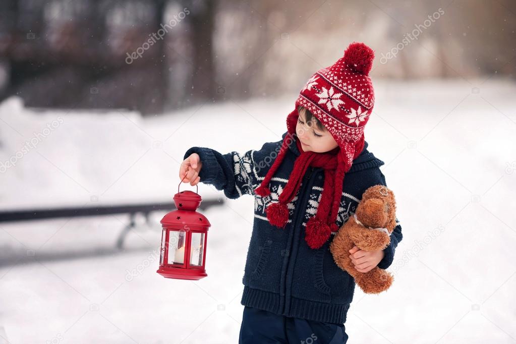 Cute little caucasian boy with teddy bear and red lantern, playi