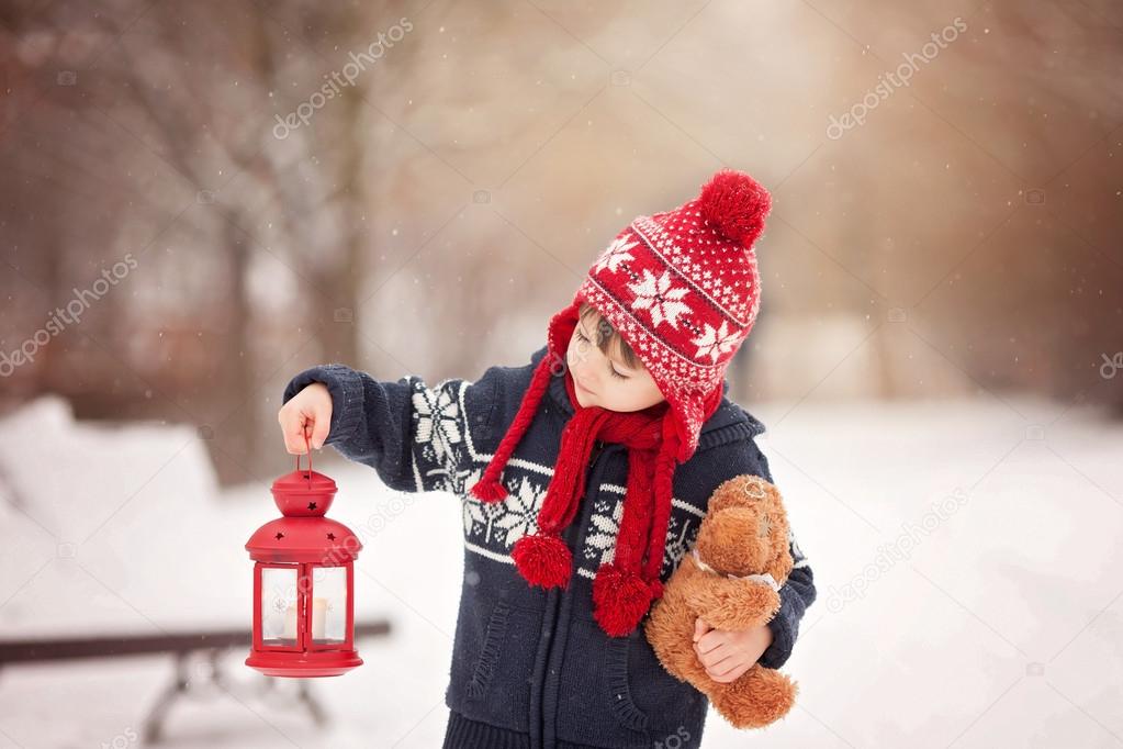 Cute little caucasian boy with teddy bear and red lantern, playi