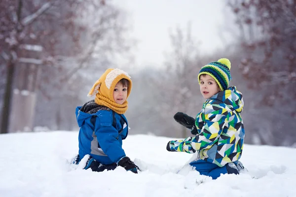 Deux garçons, frères, jouant dans la neige avec des boules de neige — Photo