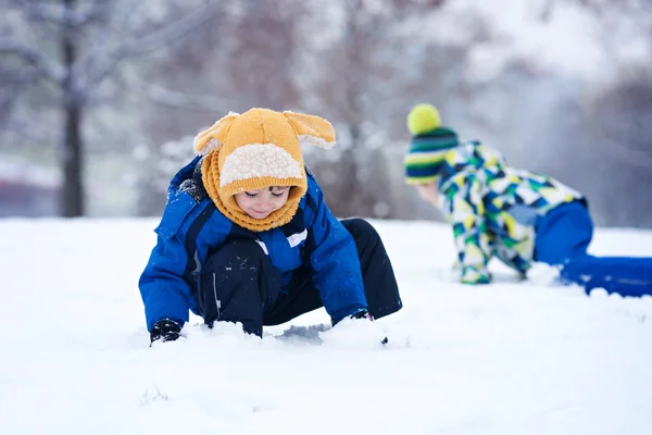 Zwei Jungen, Brüder, spielen im Schnee mit Schneebällen — Stockfoto