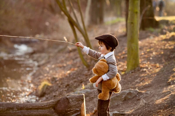 Adorable niño pequeño con su amigo oso de peluche en el parque — Foto de Stock
