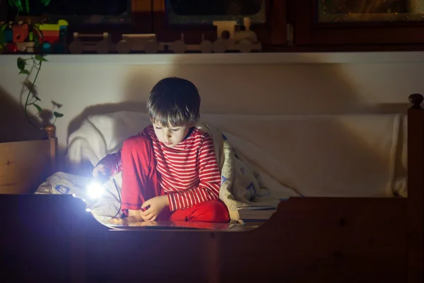 Cute little caucasian child, boy, reading book in bed — Stock Photo, Image