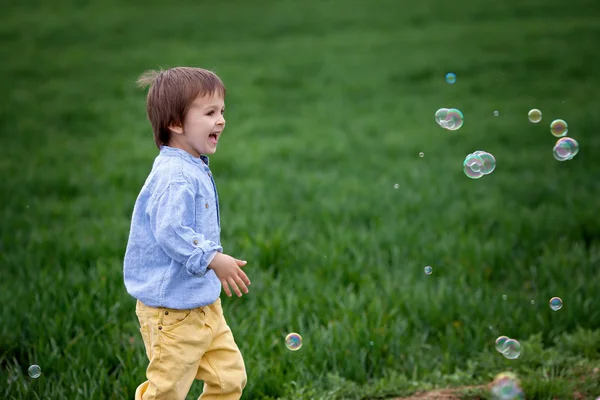 Kleiner Junge pustet Seifenblasen, Nahaufnahme Porträt — Stockfoto