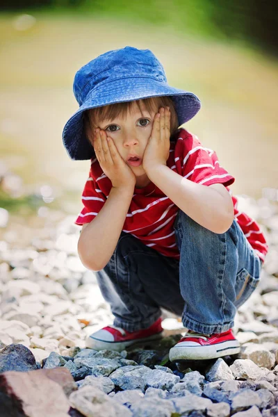 Retrato de um menino bonito com chapéu de verão em uma borda de um rio — Fotografia de Stock