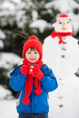Kardan adam bina Bahçe, kış döneminde, s mutlu güzel çocuk