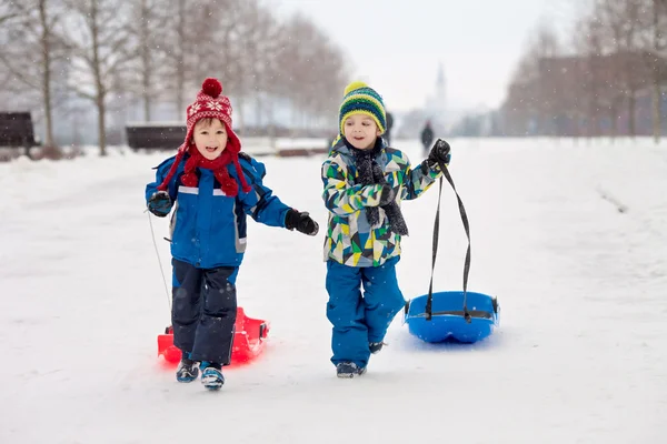 Due bambini, fratelli maschi, scivolano con bob nella neve, inverno — Foto Stock