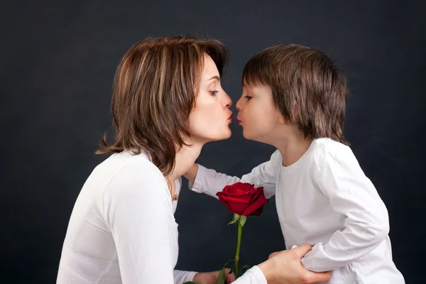 Young kid giving gorgeous red rose to his mom — Stock Photo, Image