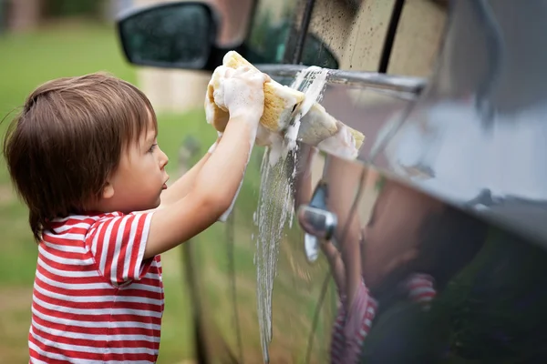 庭でスポンジでかわいい少年洗浄車 — ストック写真