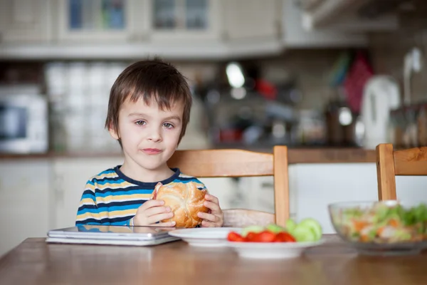 Prachtige kleine jongen, broodje eten thuis — Stockfoto