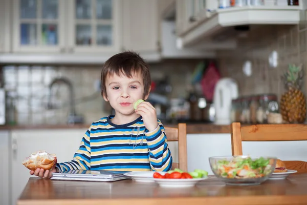 Beau petit garçon, manger un sandwich à la maison — Photo