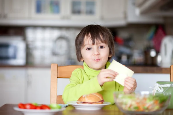 Gyönyörű kisfiú, eszik, szendvicset otthon — Stock Fotó