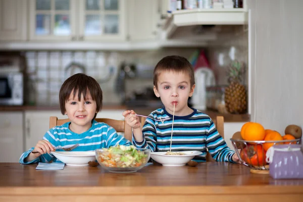 Dos dulces niños, hermanos varones, almorzando espaguetis en — Foto de Stock