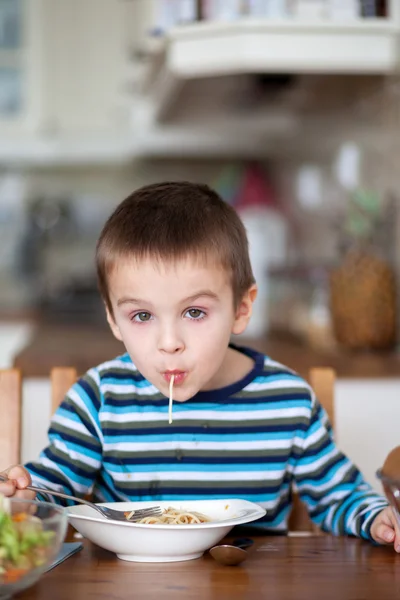 Lindo niño, comiendo espaguetis en casa para el almuerzo —  Fotos de Stock