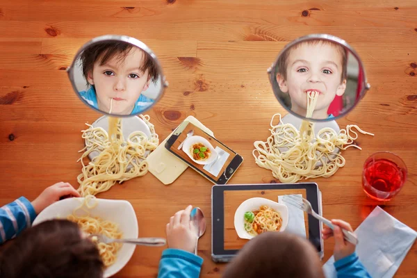Två söta barn, pojke bröder, att ha för lunch spaghetti på — Stockfoto
