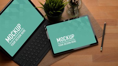 Ofiste iki adet dijital tablet ve kalemle kesilmiş çalışma masası görüntüsü.