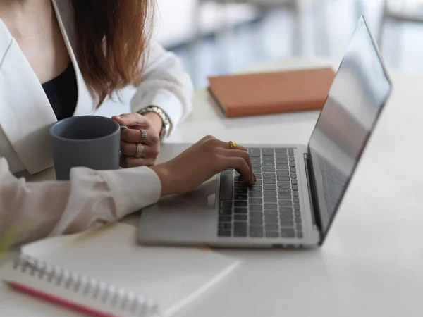 Vista Lateral Fêmea Trabalhando Com Laptop Segurando Xícara Café Mesa — Fotografia de Stock