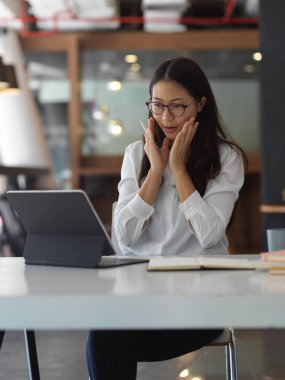 Genç iş kadını ofis odasındaki proje için heyecanlanıyor.