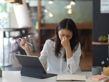 Ofis odasında çalışırken projeye üzülen genç iş kadını.