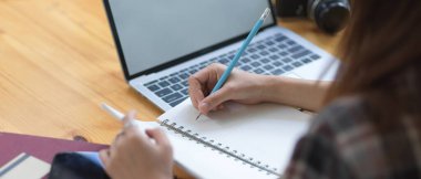 Tahta tablet kullanırken boş deftere kadın eli yazarken yan görünüm