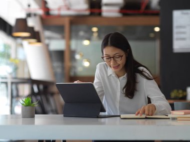 İş yerinde ofis malzemeleriyle çalışan kadın ofis çalışanının portresi.