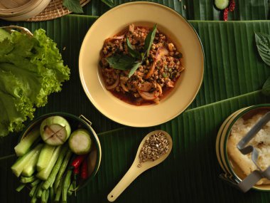 Yapışkan pirinç, sebze ve malzemelerle baharatlı domuz salatası (Larb Moo).