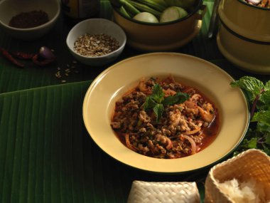 Baharatlı kıymalı domuz salatasına (Larb Moo) yapışkan pirinç ve Tayland geleneksel yemekleriyle yakından bakın.