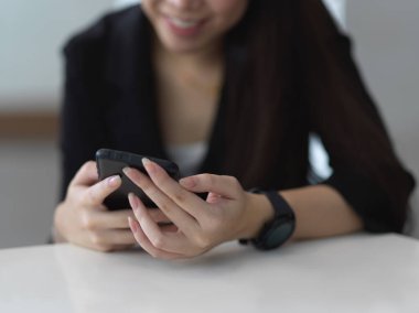 Ofiste dinlenirken akıllı telefon kullanan kadın ellerinin portresi