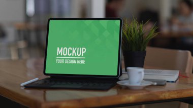 Dijital tabletin yakın görüntüsü, ofis odasındaki ahşap masanın üzerindeki kırpma yolunu içerir