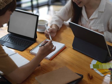 İki kız öğrencinin projelerine danışmanlık yaparken tablet maketi üzerinde çalışırken çekilmiş görüntüleri. 